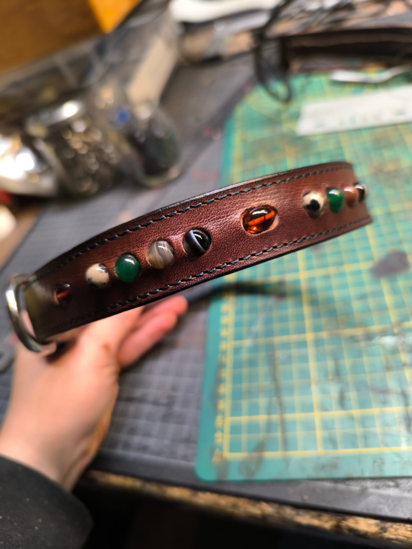Détail des pierres serties sur un collier en cuir cousu main